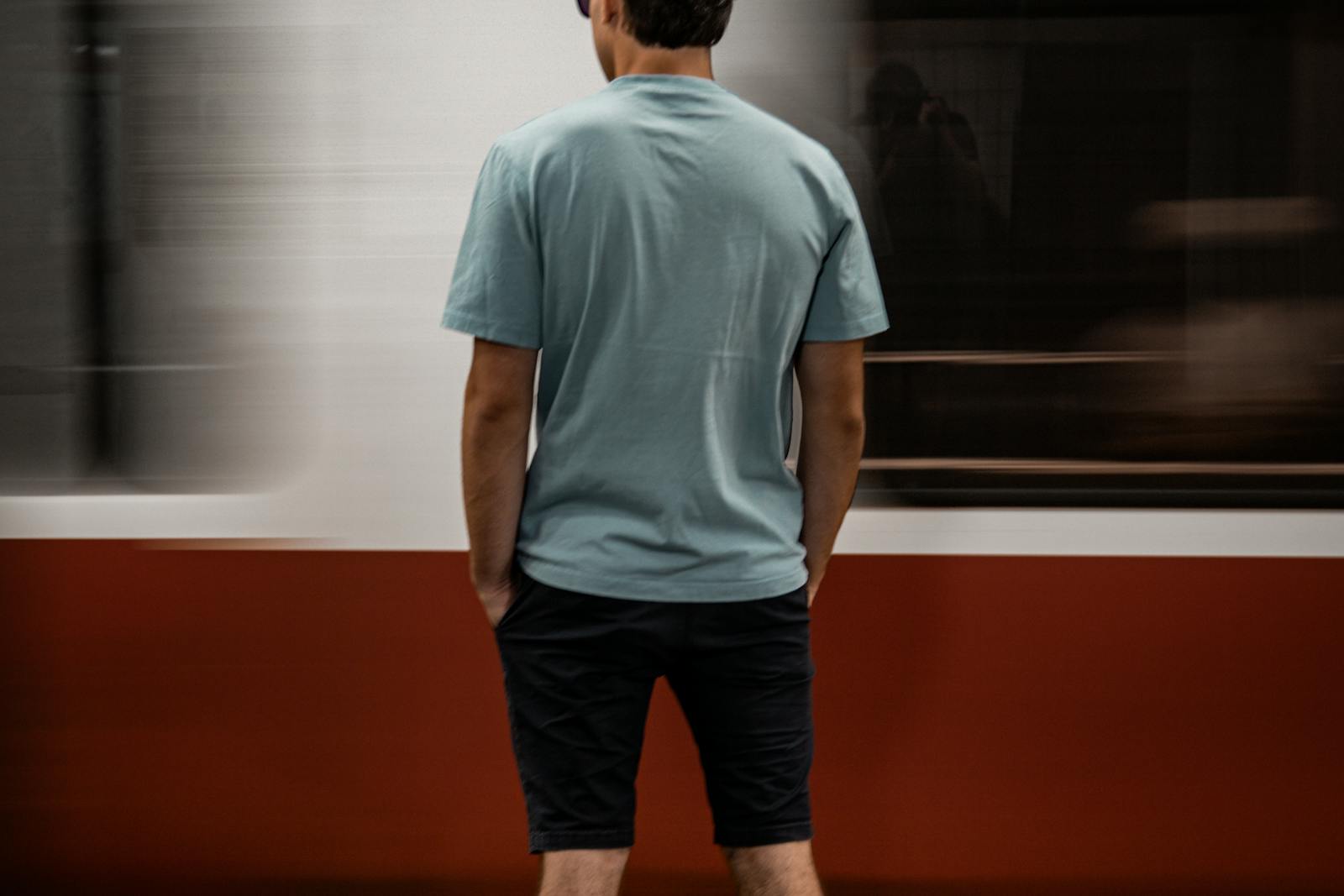 Person waiting on a Boston subway platform as a train passes