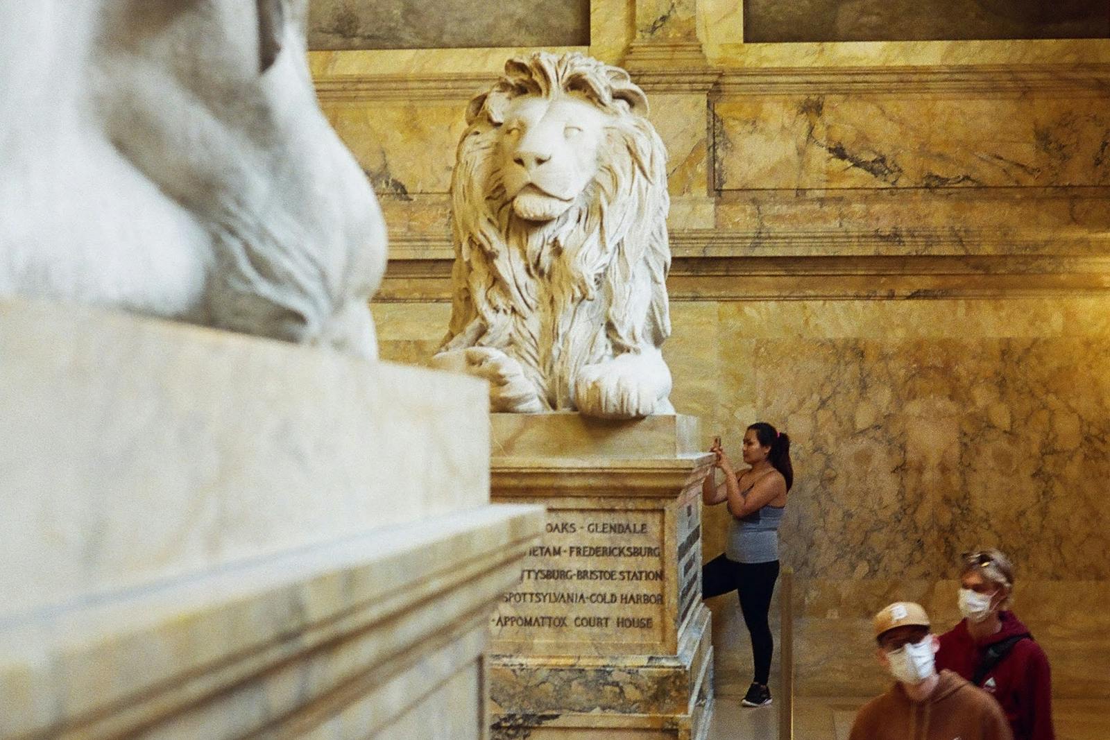 Boston museum gallery with stone lion sculptures and visitors